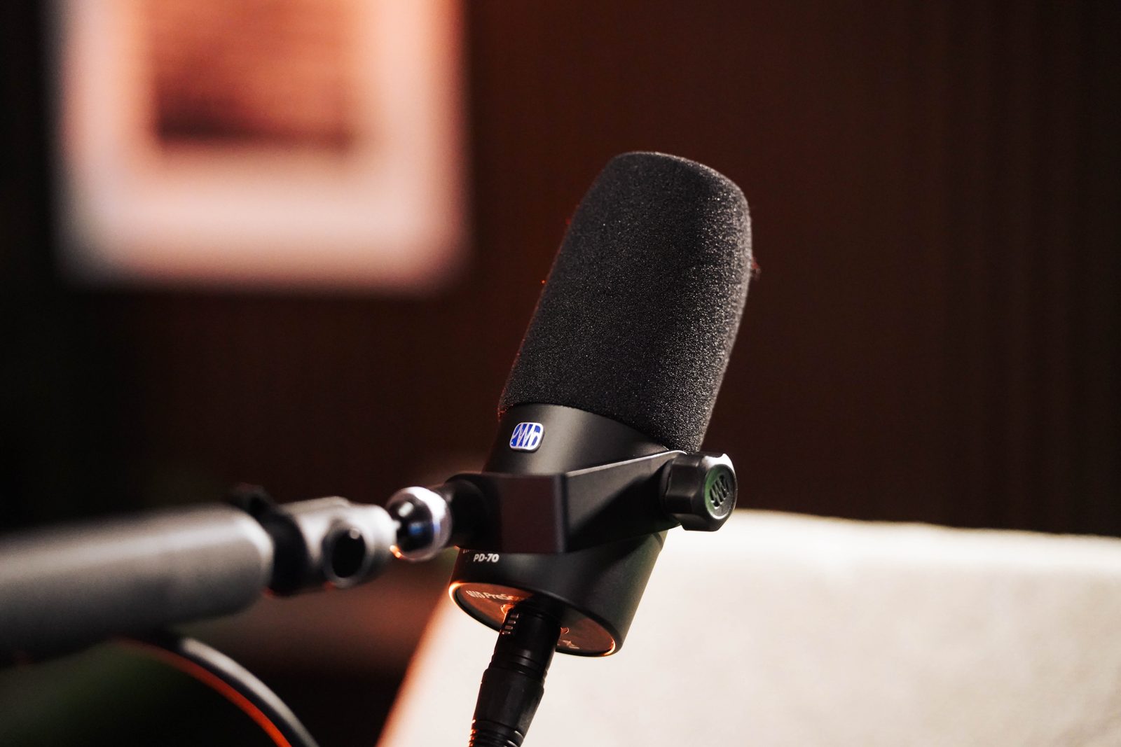 A broadcast microphone on a boom arm, ready to record